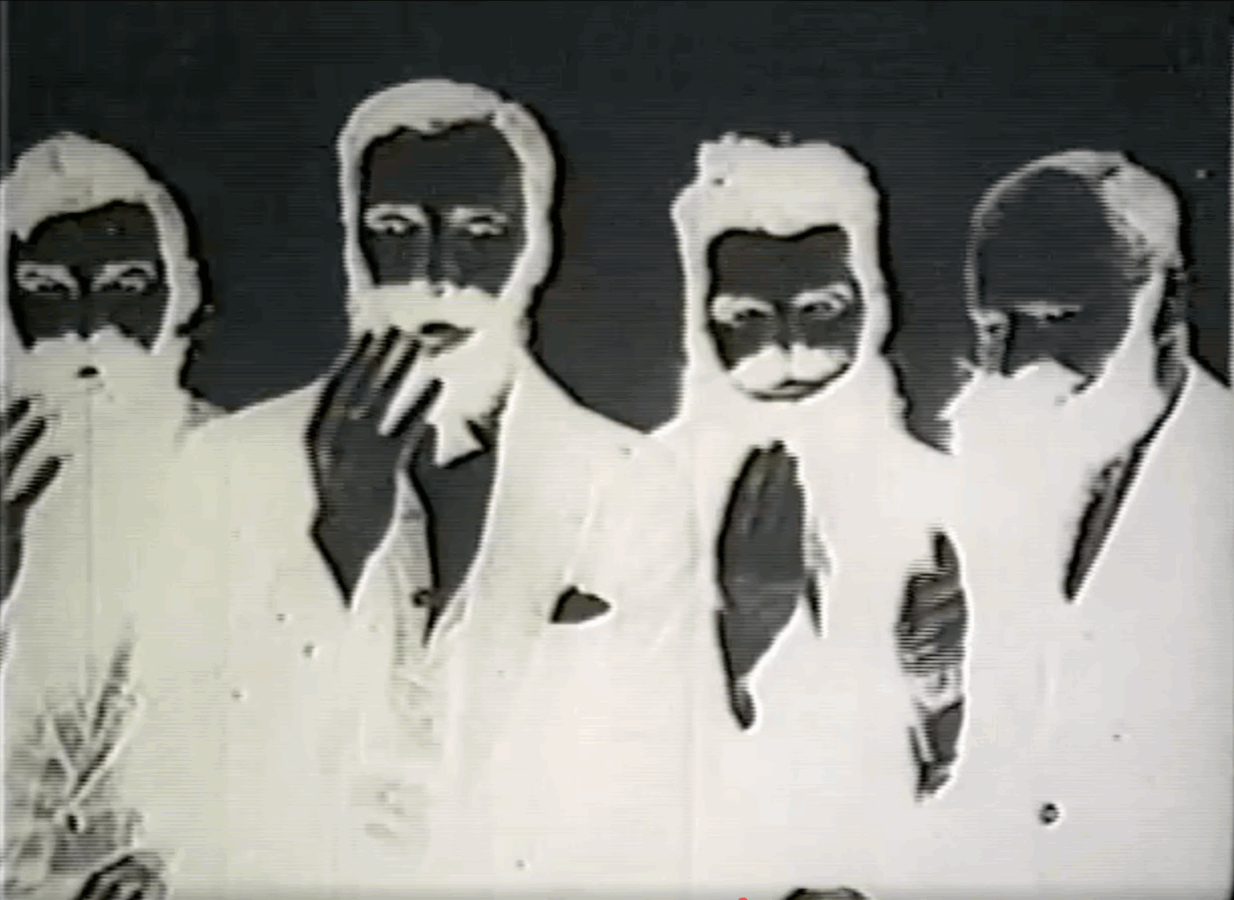 A negative image of four bearded men in suits, their faces and hands appearing white against a dark background.
